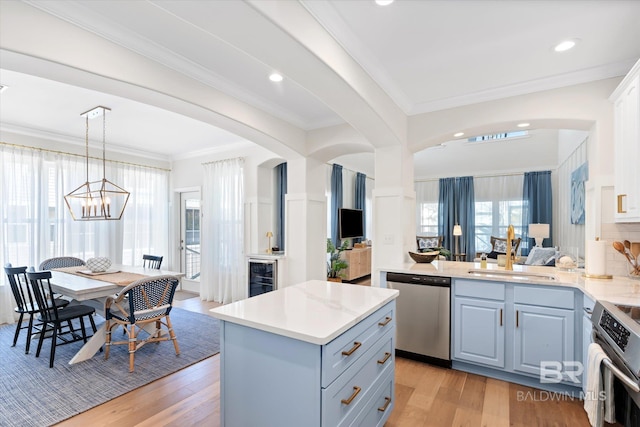 kitchen with decorative light fixtures, white cabinetry, stainless steel appliances, sink, and a notable chandelier