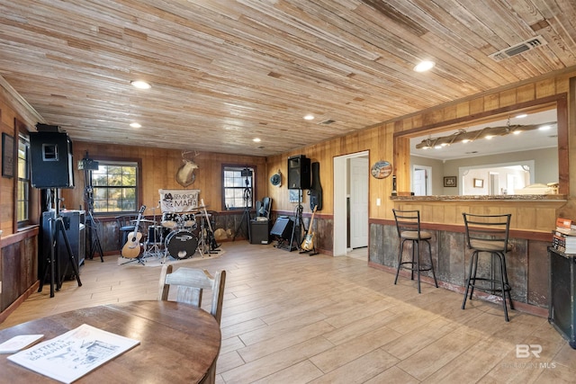 dining area featuring wood walls, wood ceiling, and light hardwood / wood-style flooring