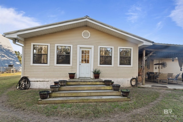 view of front of home with a front yard and a patio area