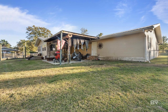 back of property with a lawn and a patio