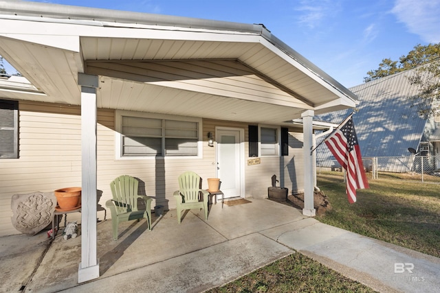 doorway to property featuring a patio and a lawn