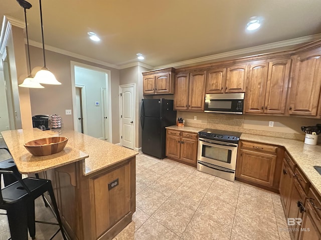 kitchen with appliances with stainless steel finishes, a breakfast bar, decorative light fixtures, light stone counters, and crown molding