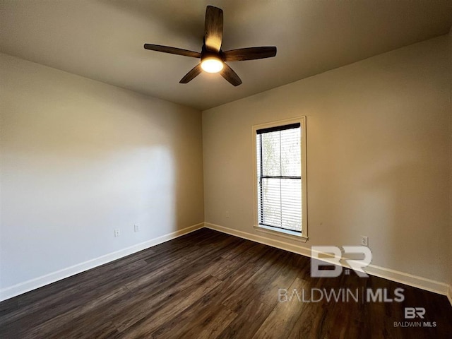 spare room with dark wood-type flooring and ceiling fan