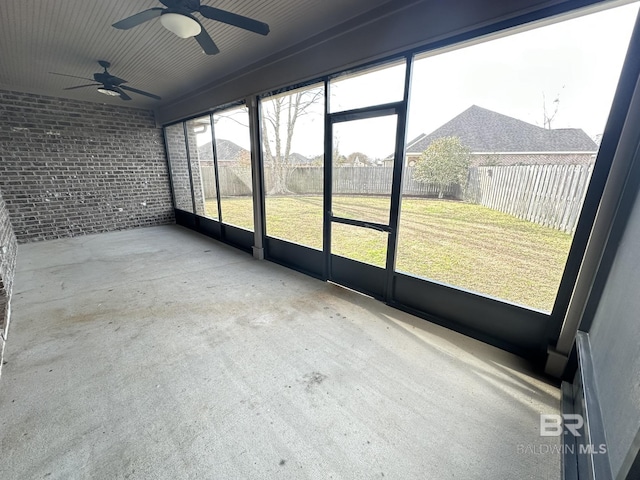 unfurnished sunroom featuring ceiling fan