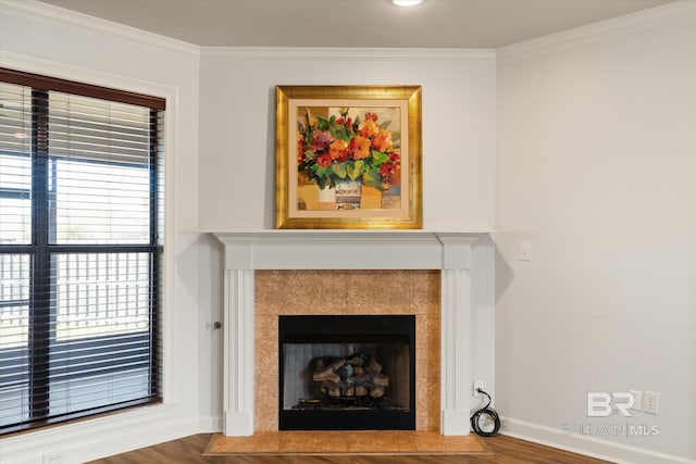 room details featuring wood-type flooring, ornamental molding, and a tile fireplace