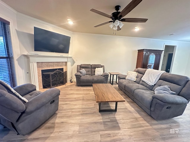 living room with ornamental molding, light hardwood / wood-style floors, and ceiling fan