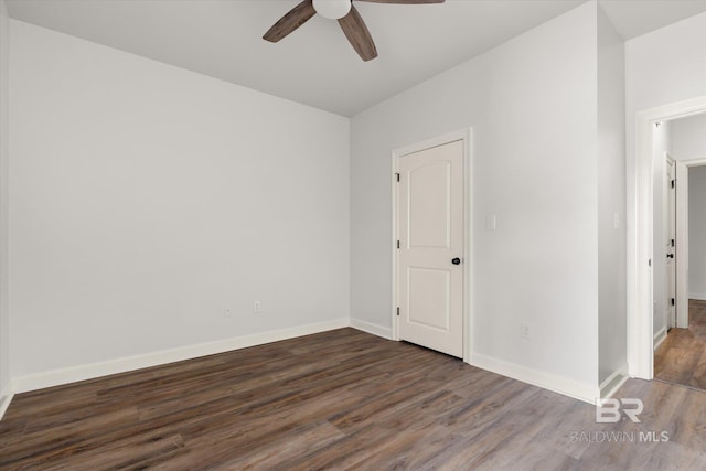 empty room with dark hardwood / wood-style floors and ceiling fan