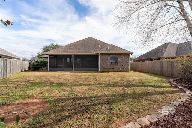 rear view of house featuring a sunroom and a yard