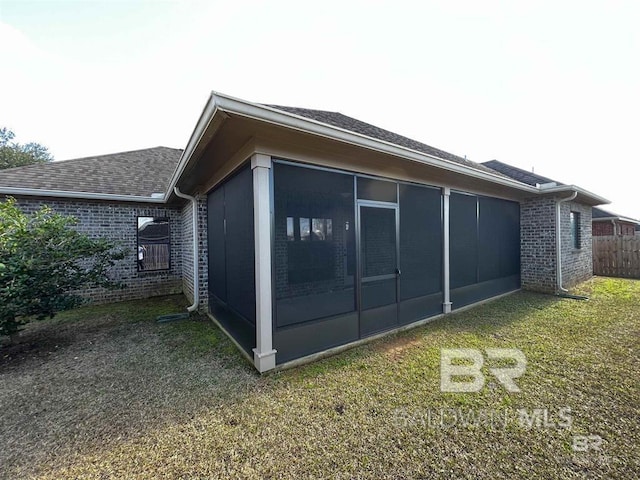 view of property exterior with a yard and a sunroom