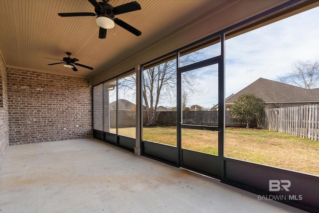 unfurnished sunroom featuring ceiling fan