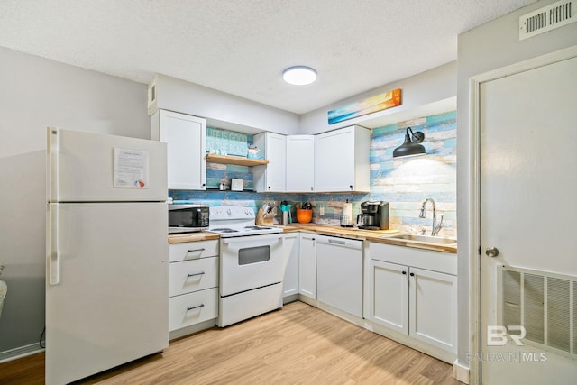 kitchen featuring light hardwood / wood-style flooring, white appliances, white cabinets, decorative backsplash, and sink