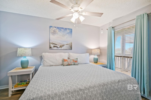 bedroom with dark hardwood / wood-style flooring, ceiling fan, and a textured ceiling