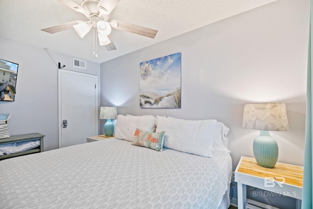 bedroom with a textured ceiling and ceiling fan