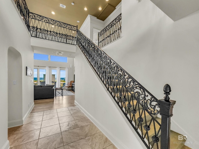 staircase featuring light hardwood / wood-style flooring and a high ceiling