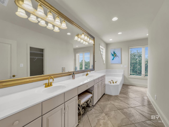 bathroom with double vanity, a tub, and tile patterned floors