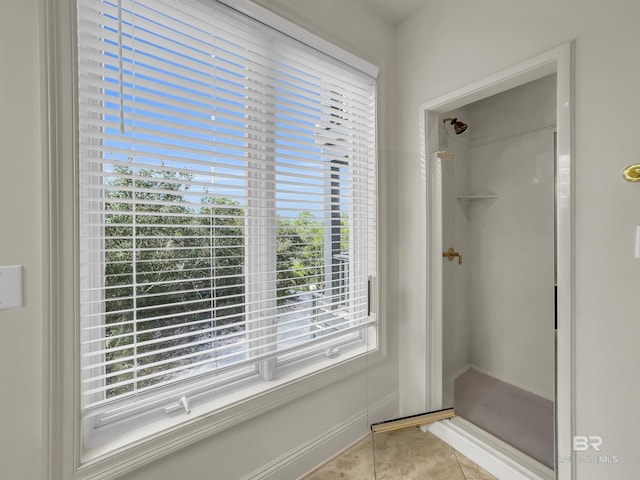 bathroom with tile patterned flooring, a healthy amount of sunlight, and walk in shower