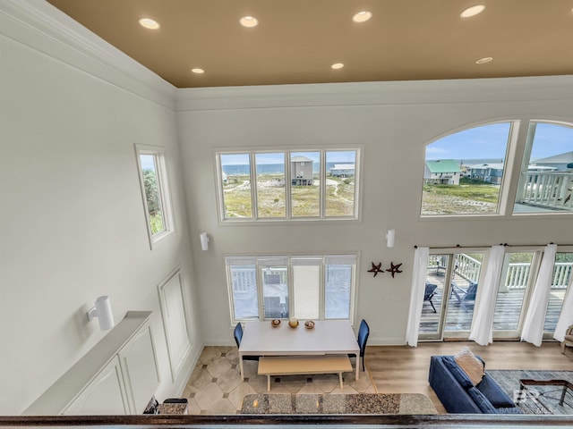 living room with light wood-type flooring and a towering ceiling