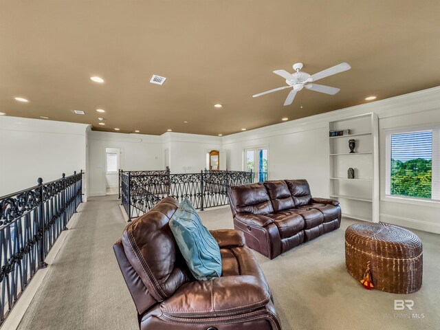 living room featuring crown molding, light carpet, and ceiling fan