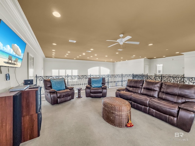 carpeted living room with ornamental molding and ceiling fan