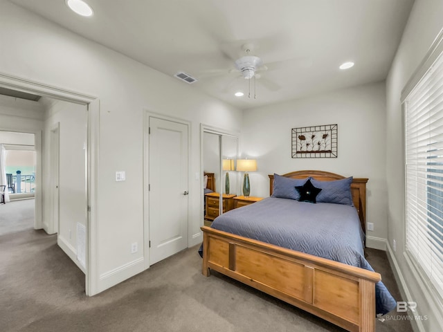 carpeted bedroom with a closet, multiple windows, and ceiling fan