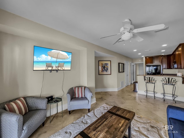 tiled living room featuring ceiling fan with notable chandelier