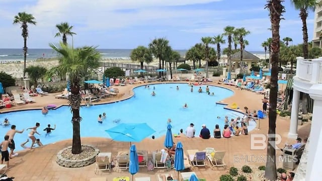 view of pool with a patio and a water view