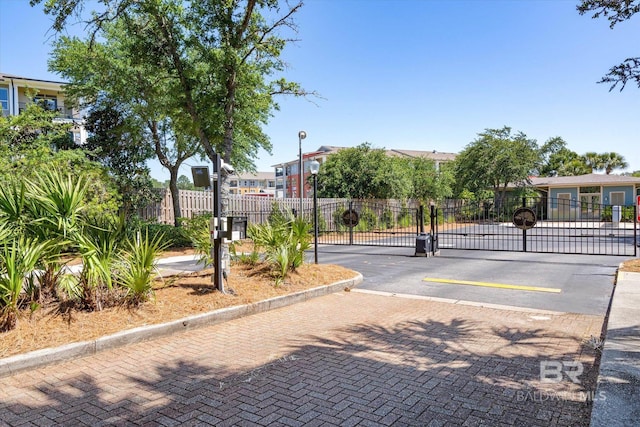 1430 Regency Rd Unit C103, Gulf Shores, AL 36542 - view of decorative street with a gate, a gated entry, curbs, street lighting, and a residential view