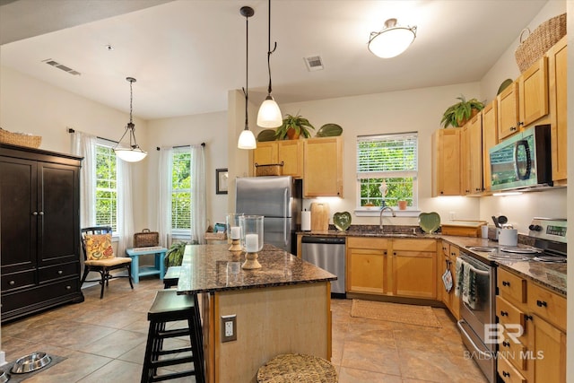 1430 Regency Rd Unit C103, Gulf Shores, AL 36542 - kitchen featuring stainless steel appliances, plenty of natural light, a kitchen island, and dark stone countertops