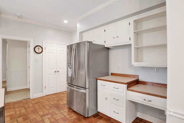 kitchen with stainless steel refrigerator with ice dispenser, ornamental molding, and white cabinets