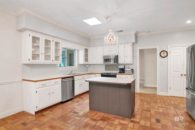 kitchen with decorative light fixtures, a kitchen island, stainless steel appliances, and white cabinets