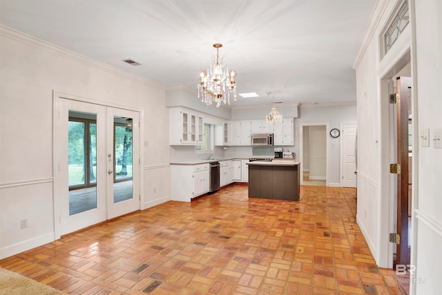 kitchen featuring ornamental molding, a kitchen island, stainless steel appliances, and white cabinetry