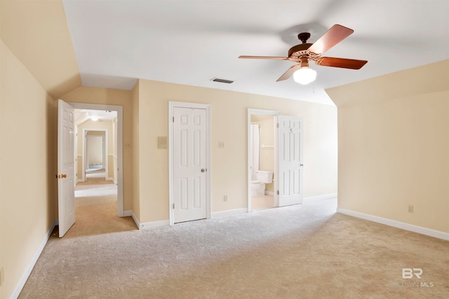 unfurnished bedroom with ceiling fan, lofted ceiling, light carpet, and ensuite bathroom