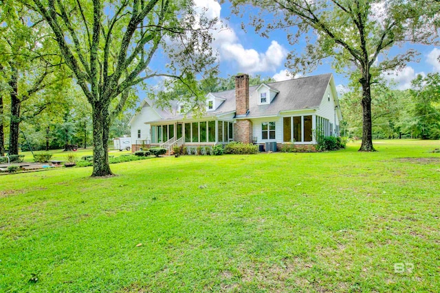 new england style home with a sunroom and a front yard