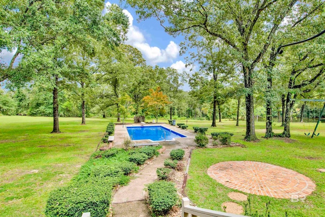 view of swimming pool featuring a lawn and a patio