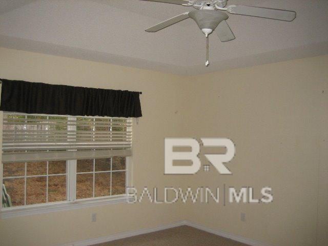 empty room featuring baseboards and ceiling fan