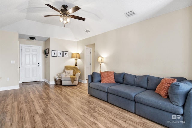 living area with ceiling fan, wood finished floors, visible vents, and baseboards