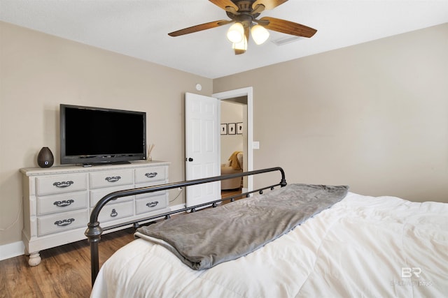 bedroom featuring ceiling fan, baseboards, and wood finished floors