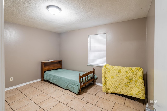 bedroom with a textured ceiling and light tile patterned flooring