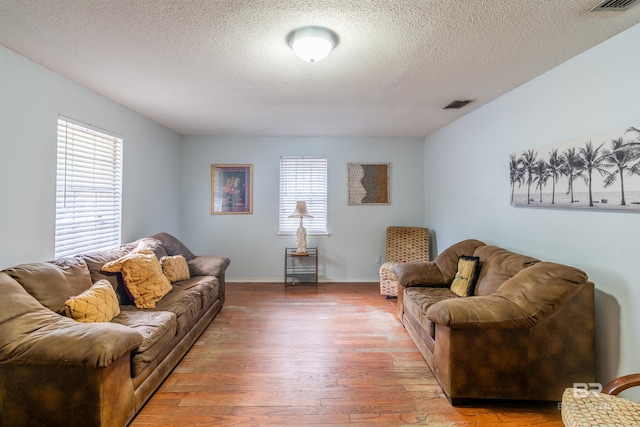 living room with wood-type flooring and a textured ceiling