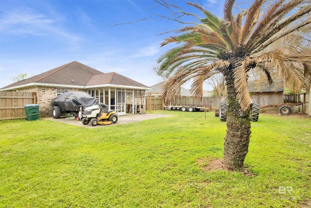 back of house with a yard, a patio area, a fenced backyard, and a sunroom