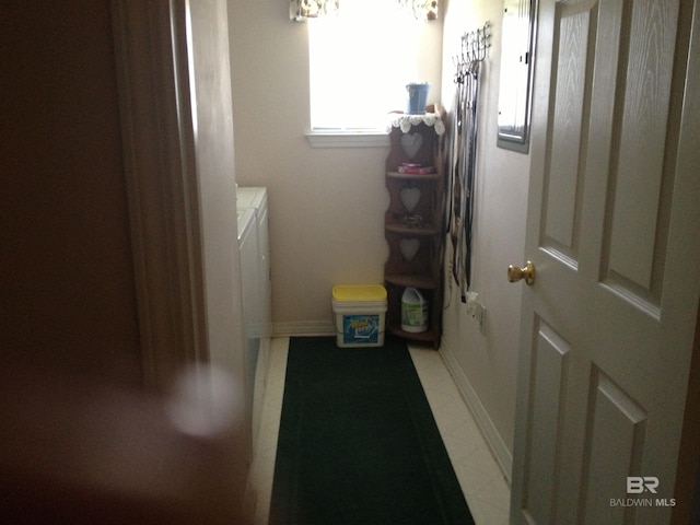 laundry area with laundry area, washing machine and dryer, and baseboards