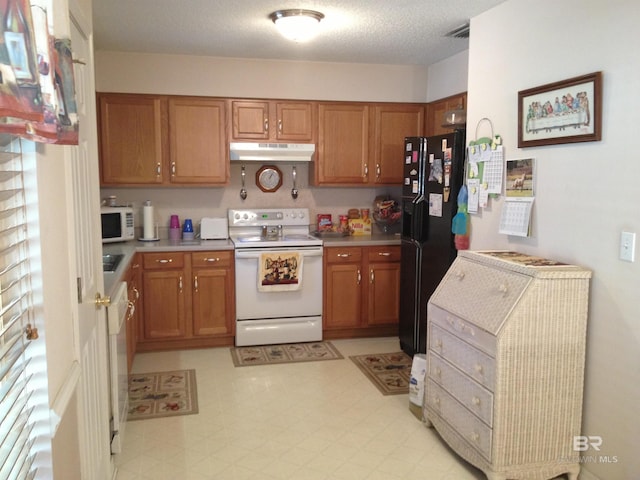 kitchen featuring white appliances, brown cabinetry, and light floors