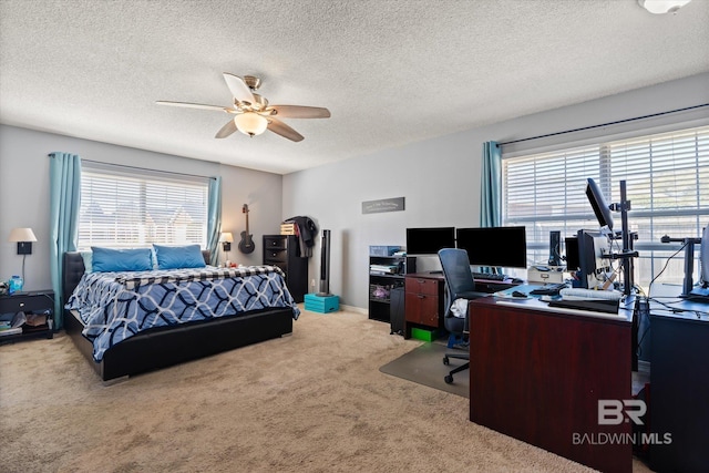 carpeted bedroom with a textured ceiling and a ceiling fan