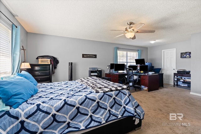 bedroom featuring light colored carpet, ceiling fan, and a textured ceiling