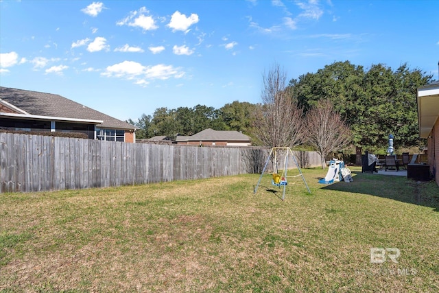 view of yard with a fenced backyard and a playground