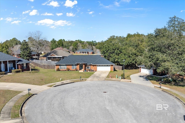 view of front facade featuring a front yard, concrete driveway, and fence