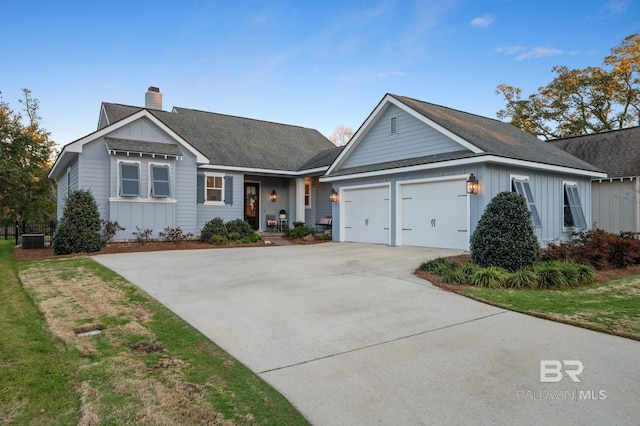 ranch-style home featuring driveway, board and batten siding, a front yard, a garage, and a chimney