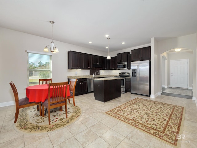 1234 Surrey Loop, Foley, AL 36535 - kitchen with stainless steel appliances, arched walkways, light countertops, a kitchen island, and pendant lighting