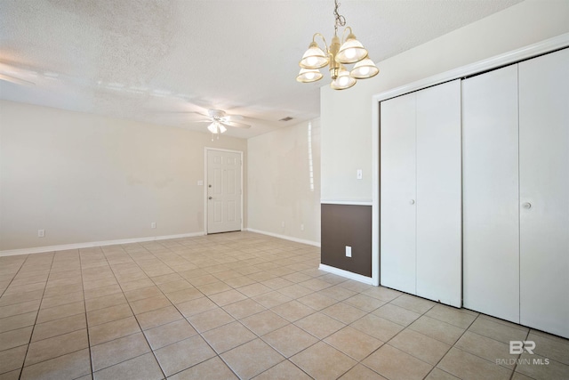 interior space featuring a textured ceiling and ceiling fan with notable chandelier