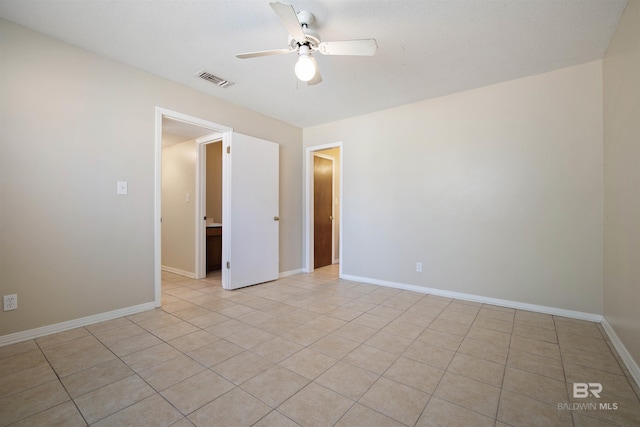 tiled spare room with ceiling fan